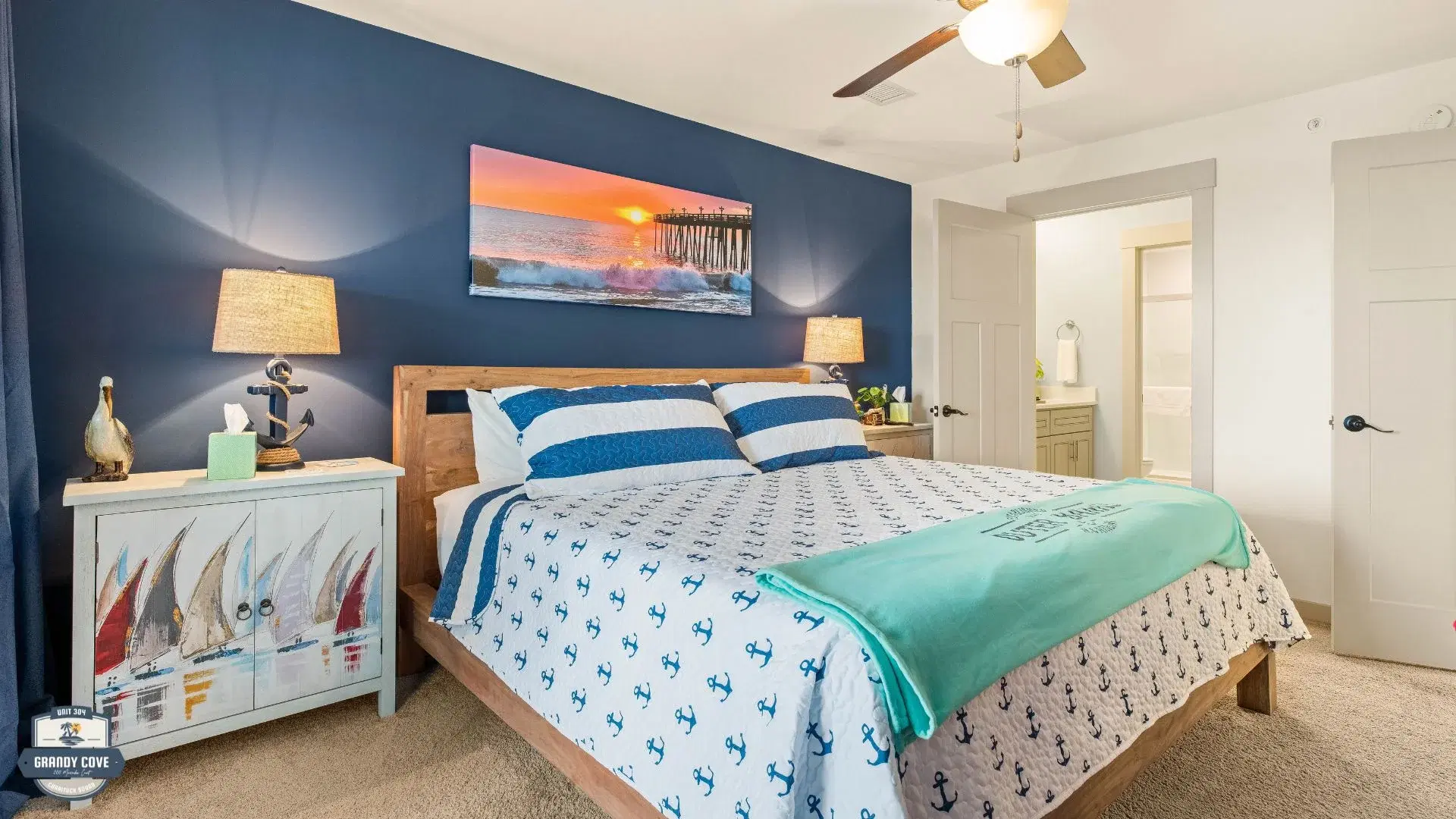 Grandy Cove master bedroom with blue accent wall and nautical nightstand