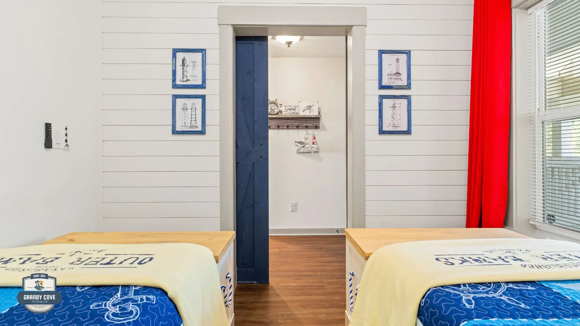 Grandy Cove third bedroom with shiplap wall and lighthouse art